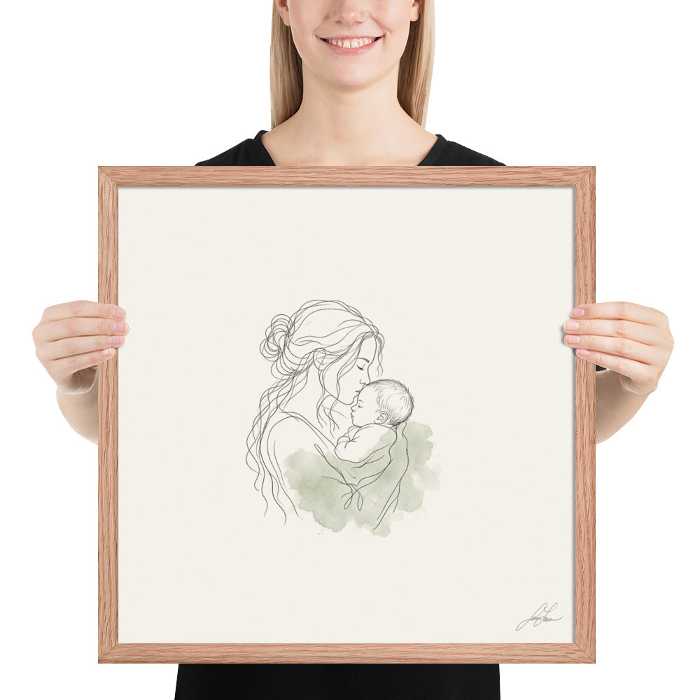 First Kiss, a fine-line drawing of a mother kissing her baby, Beloved print by Jamie Lawrence in a Red Oak frame, held to show scale