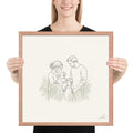 All of Us, a fine-line drawing of a family gathered close, Beloved print by Jamie Lawrence in a Red Oak frame, held to show scale