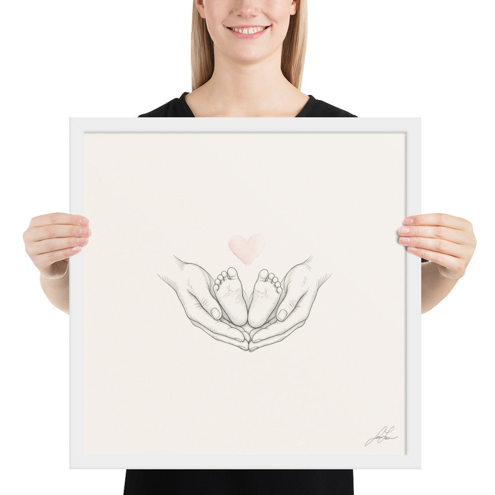 Ten Little Toes, a fine-line drawing of a parent's hands cradling a baby's feet beneath a small blush heart, Beloved print by Jamie Lawrence in a White frame, held to show scale